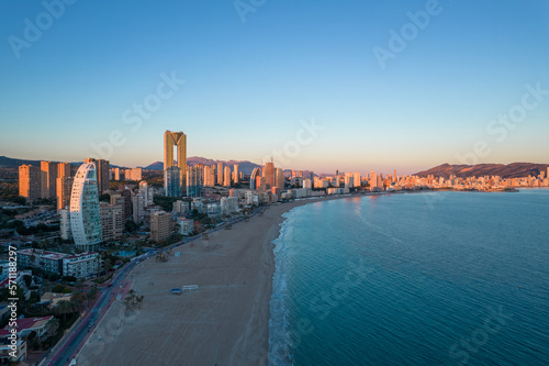 Benidorm Playa de Poniente beach at sunset with tall buildings. Tourist city with skyscrapers