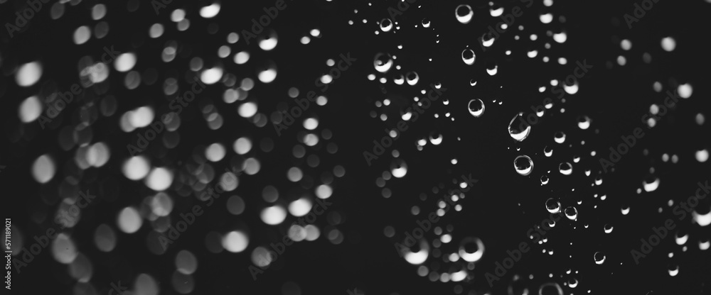 Atmospheric minimal grayscale backdrop with rain droplets on glass. Wet window with rainy drops and dirt spots closeup. Blurry minimalist monochrome background of dirty window glass with raindrops. Atmospheric minimal grayscale backdrop with rain droplets on glass. Wet window with rainy drops and dirt spots closeup. Blurry minimalist monochrome background of dirty window glass with raindrops.