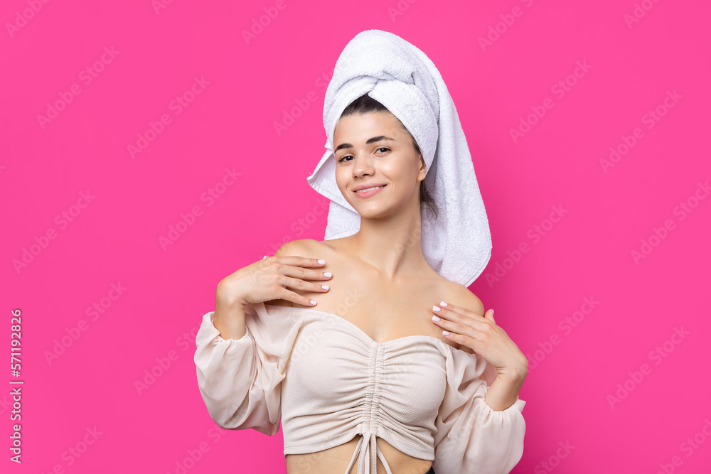 Portrait of young beautiful woman after bath. Beauty face of a cheerful attractive girl with towel on head against a pink background. Portrait of young beautiful woman after bath. Beauty face of a cheerful attractive girl with towel on head against a pink background.