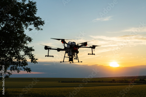 Fototapeta Naklejka Na Ścianę i Meble -  Agricultural technology smart farm concept. Farmer technicians remotely fly agricultural drones to fly to spray fertilizer in fields.