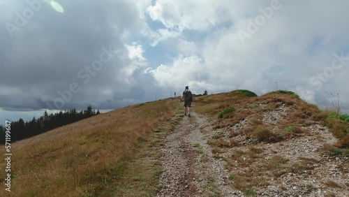 Following shot of a guy hiking through a trail toward the top of a mountain photo