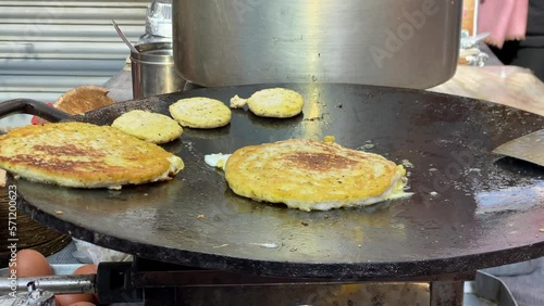 Some Newari bara frying on a skillet at a local market in Nepal. photo