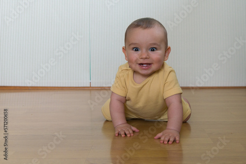 Baby boy crawling in yellow clothes 