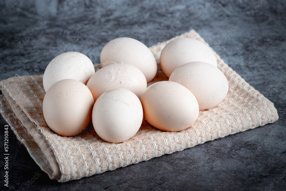 Chicken eggs on beige towel on grey background Chicken eggs on beige towel on grey background