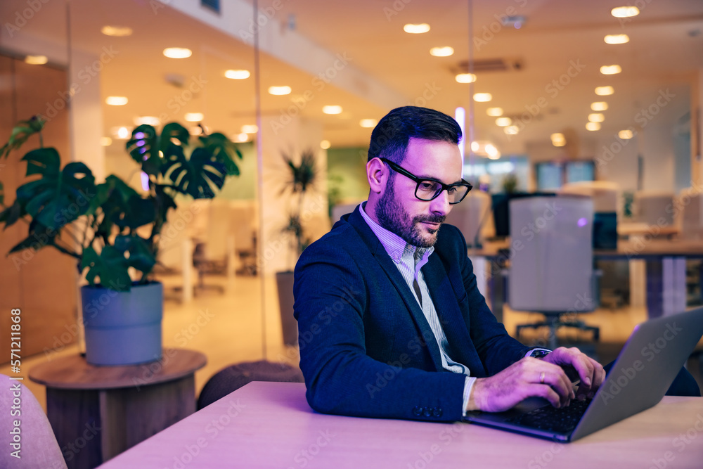 Focused male boss typing on a laptop, sitting at the office, elegantly dressed. Focused male boss typing on a laptop, sitting at the office, elegantly dressed.