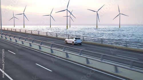 Aerial shot of an autonomous electric car driving along a bridge or coastal highway into the sunset with wind turbines in background. Green energy concept. Realistic high quality 3d animation. photo