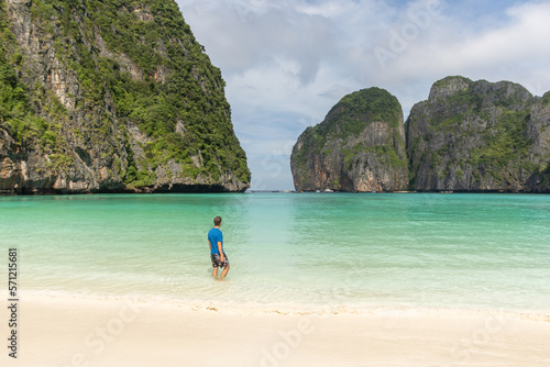 Man walking on the lonely beach of maya bay without people, with its transparent turquoise waters and white sands