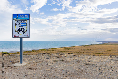View to the coast of Cabo Virgenes and aluminum sign marking kilometer 0 of the famous Ruta40 in southern Argentina, Patagonia, South America