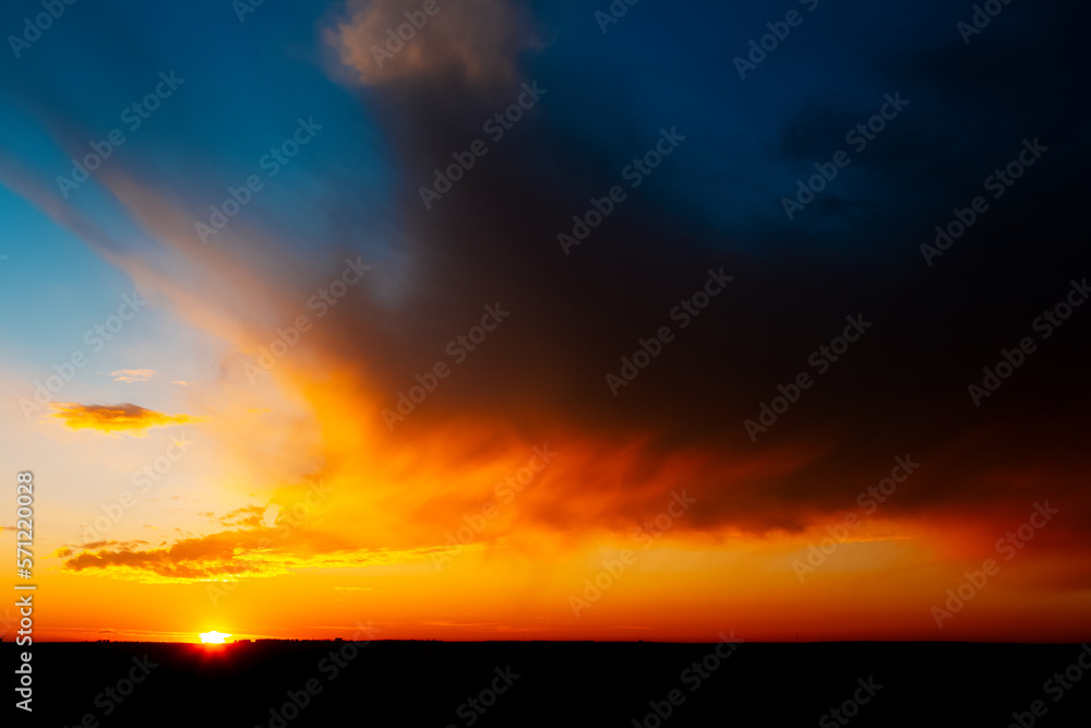 Colourful landscape of beautiful sunset with dark clouds.