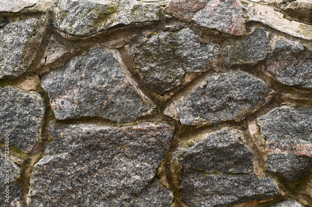 Fototapeta premium The texture of a stone wall. A stone wall as a background or texture. Part of a stone wall, for background or texture.