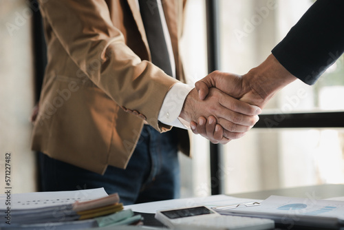 Business investor group holding hands, Two businessmen are agreeing on business together and shaking hands after a successful negotiation. Handshaking is a Western greeting or congratulation.