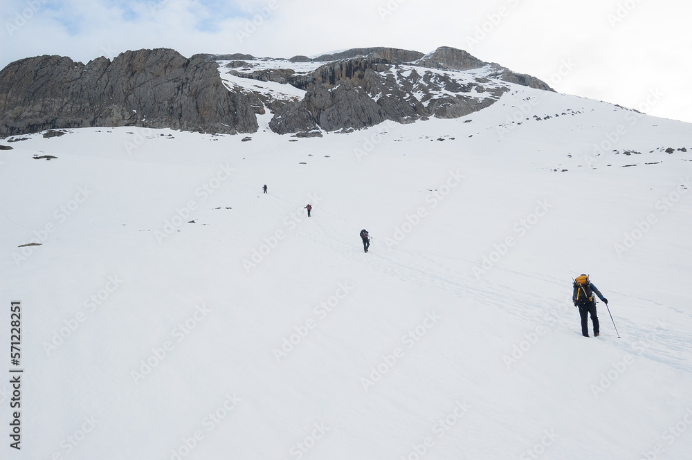 Snow hikers climbing a snowy mountain in a sunny day Snow hikers climbing a snowy mountain in a sunny day