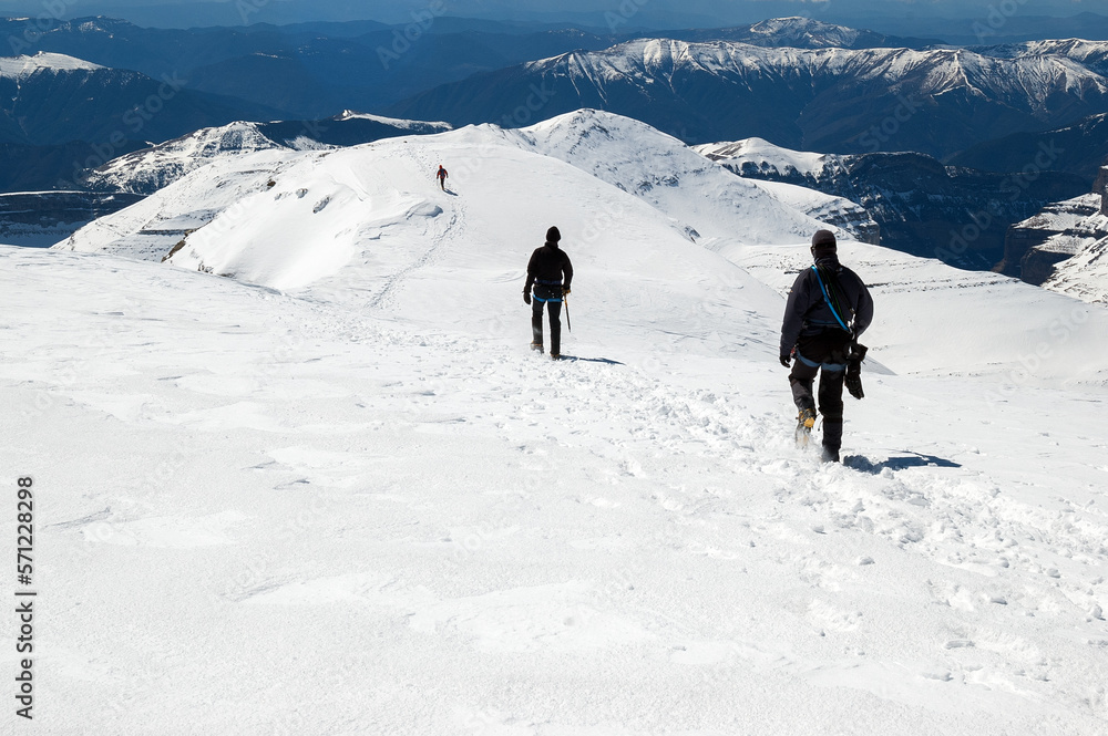 Snow hiker walking in a snowy hillside in a sunny day