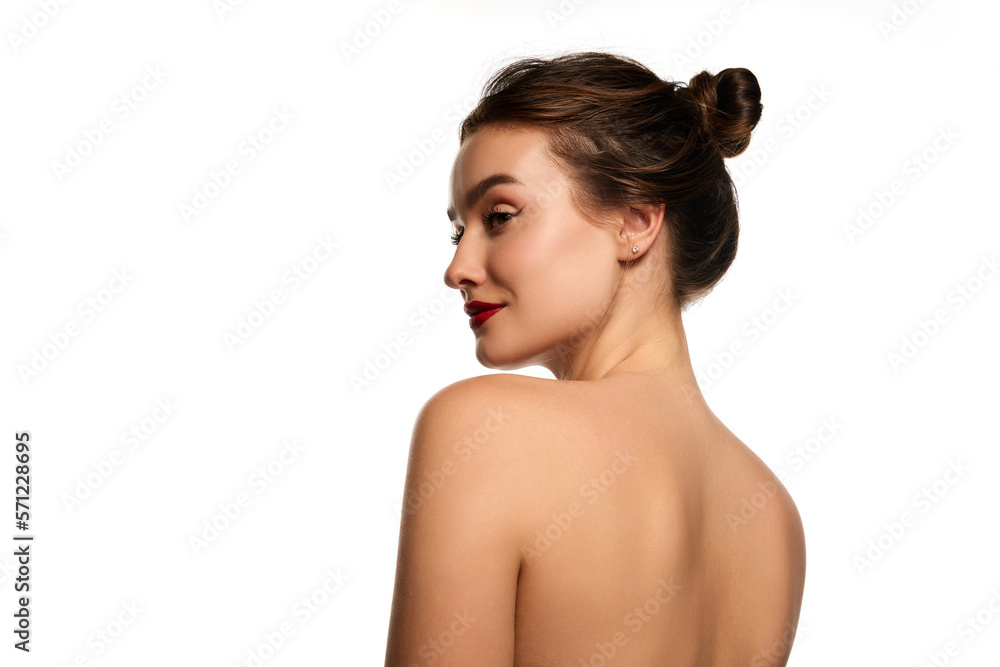 Side view portrait. Naked shoulders. One beautiful brunette girl posing against white studio background. Concept of natural beauty, youth, health, wellness, femininity, make-up Side view portrait. Naked shoulders. One beautiful brunette girl posing against white studio background. Concept of natural beauty, youth, health, wellness, femininity, make-up