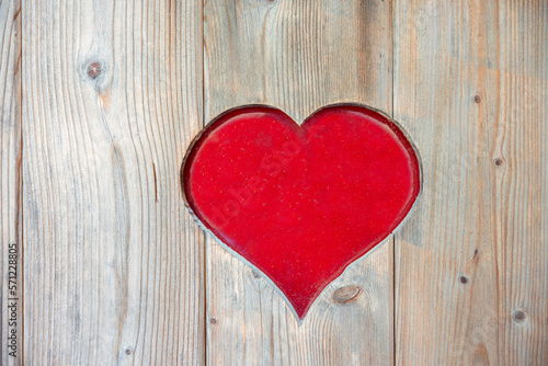 rustic wooden board with sawn out heart shape. love backgrounds with red copy space