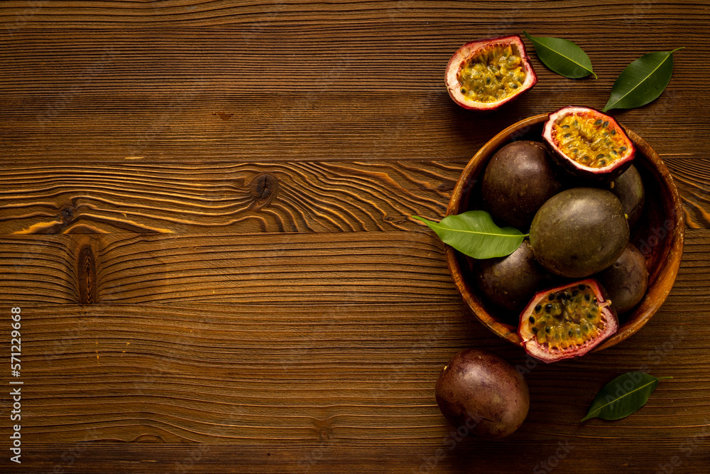 Healthy snack - fresh passion fruit in wooden bowl. Top view Healthy snack - fresh passion fruit in wooden bowl. Top view