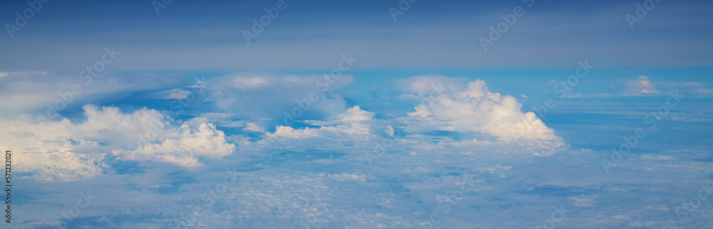 Obraz premium White cumulus clouds seen from the passenger airplane on sunny summer day, aerial view