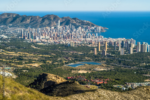 skyscrapers, apartment buildings and hotels with the sea in the background. Dense buildings of the city of Benidorm, seen from above. Blue sky, horizontal