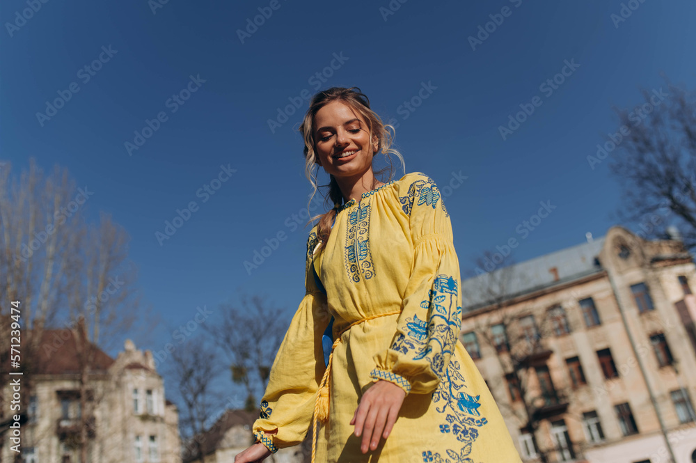 A young girl stands in a Ukrainian national ethnic embroidered dress at sunset on a sunny day. Independence Day. Ukraine