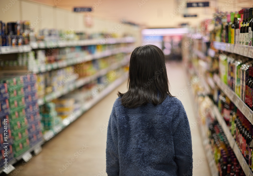 冬のスーパーで買い物をしている小学生の女の子の様子