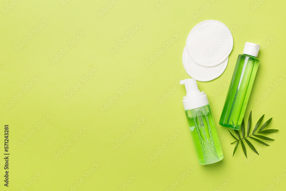 Foaming facial cleanser and micellar water on color background, top view Foaming facial cleanser and micellar water on color background, top view
