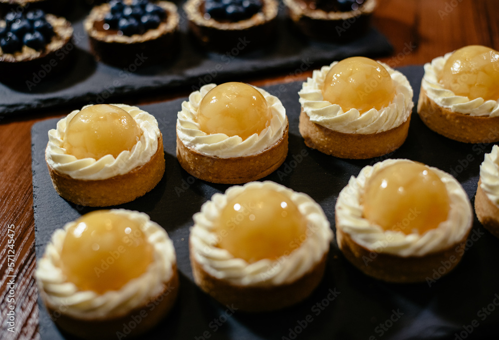 Lemon tartlets are on display in a coffee shop. An exquisite European dessert with fruit filling. Lemon tartlets are on display in a coffee shop. An exquisite European dessert with fruit filling.