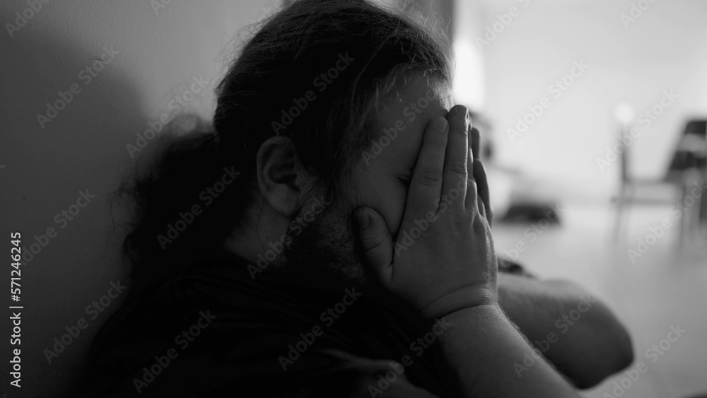 One overweight man suffering from depression at home corridor in emotional pain in monochromatic black and white One overweight man suffering from depression at home corridor in emotional pain in monochromatic black and white