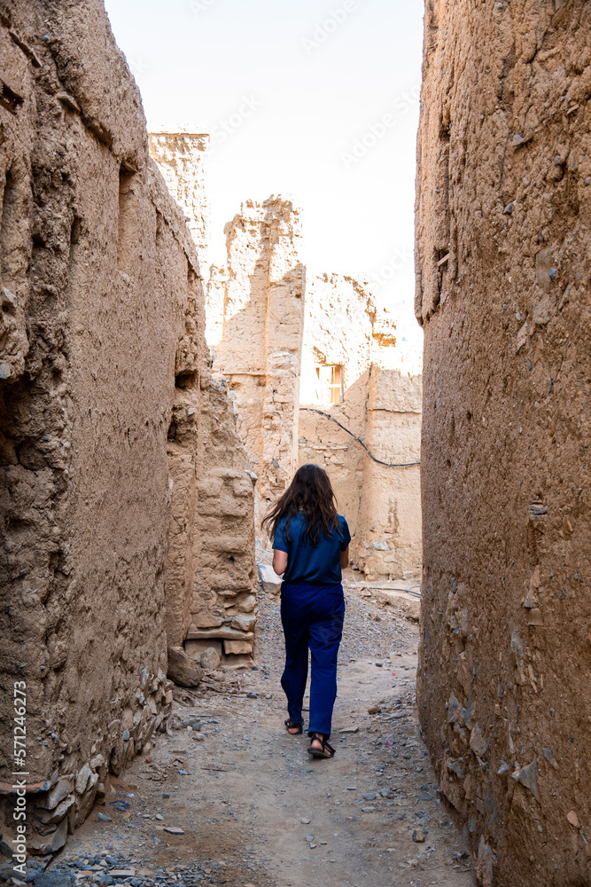 Woman walking through village ruins