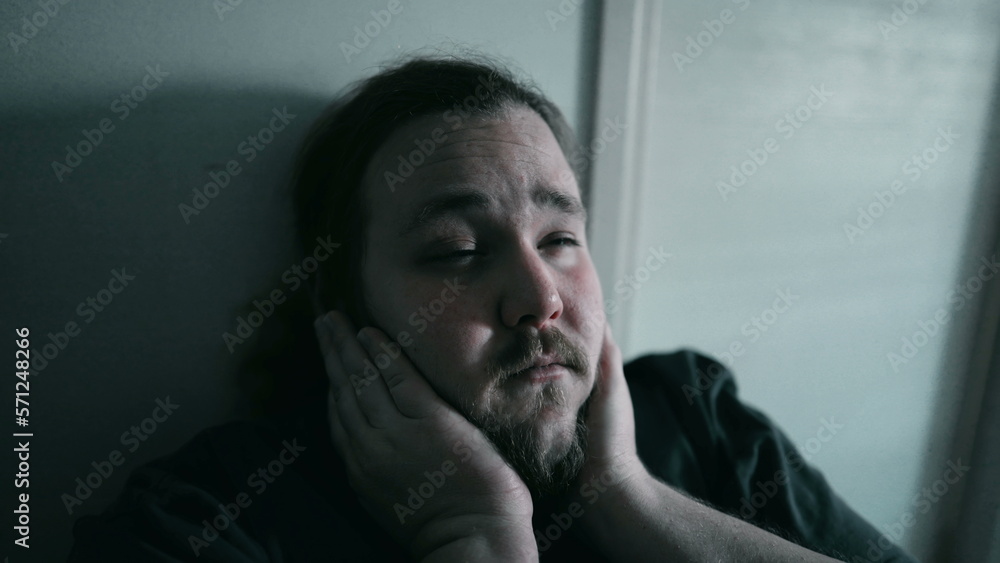 Depressed person sitting at home in the dark feeling despair Depressed person sitting at home in the dark feeling despair