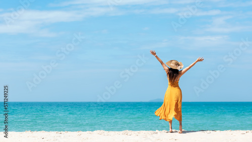 Summer vacations. Lifestyle woman relax and chill on beach background.  Asia happy young people with white dress raise arm on the wave sea  summer trips walking enjoy  tropical beach