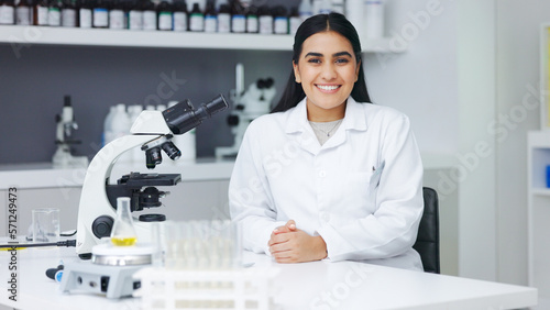 Fotografie Portrait of a female scientist using a microscope in a research lab