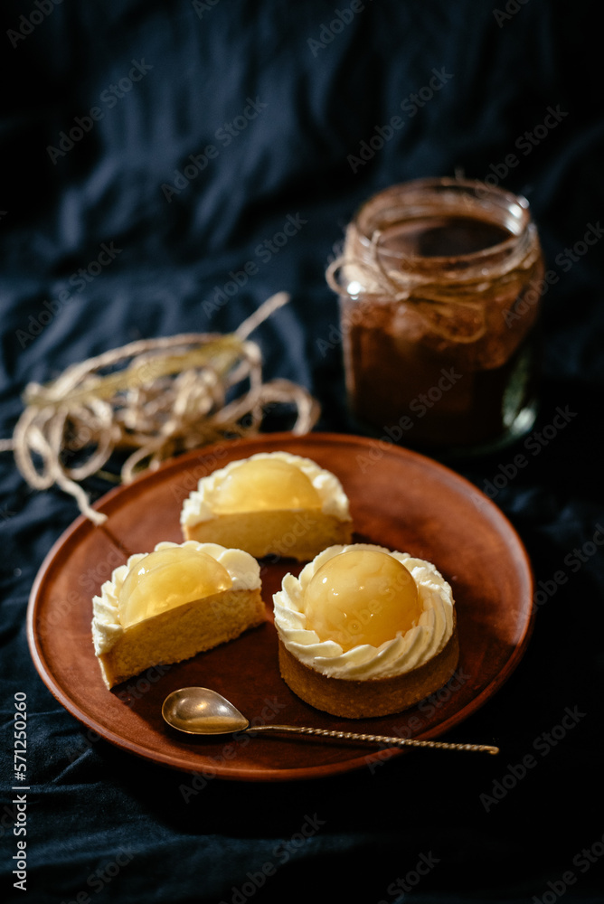 Lemon tartlets on a black background. An exquisite European dessert with fruit filling. Lemon tartlets on a black background. An exquisite European dessert with fruit filling.
