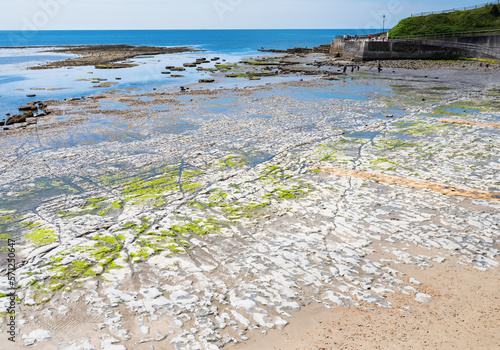 Famous Lyme Regis beach, world heritage site in Dorset, South West England. View of stones and liffs and blue sea. The beach is full of fossils. Selective focus photo