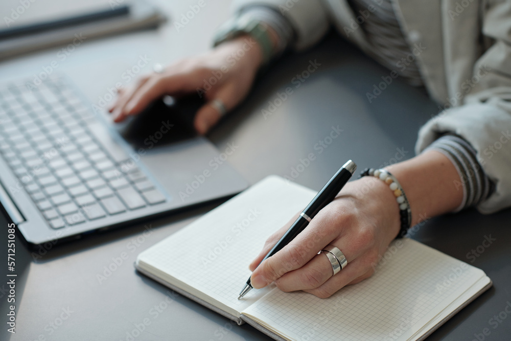 Hands of young businesswoman with pen over blank page of notebook writing down plan of working day or points of new business project Hands of young businesswoman with pen over blank page of notebook writing down plan of working day or points of new business project