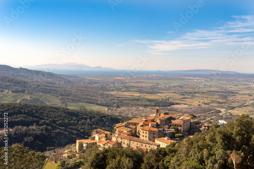 Italy Grosseto Maremma, route in MTB and EMTB in the woods of Gavorrano up to Mount Calvo, panoramic view of the village and the valley to the sea, Elba Island in the background