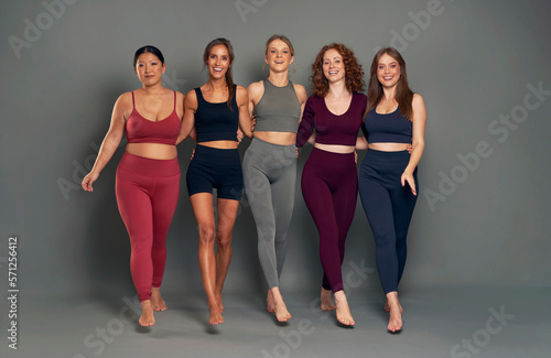 Portrait of five women in sports clothes walking towards camera in studio shot