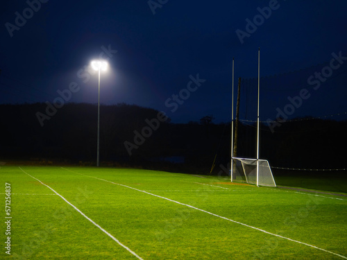 Training ground with grass illuminated by modern powerful LED lights. Efficient modern technology. Nobody. Sport field with tall goal posts for rugby, camogie, hurling and Gaelic football. Irish sport photo