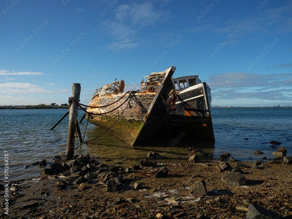 Remains ruins of an old historical capsized tilted fishing boat ship wreck at Greenpoint Ship Graveyard New Zealand