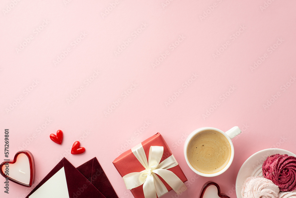 Mother's Day concept. Top view photo of red giftbox with bow envelopes plate with meringue cup of hot drinking and heart shaped candles on isolated pastel pink background with copyspace Mother's Day concept. Top view photo of red giftbox with bow envelopes plate with meringue cup of hot drinking and heart shaped candles on isolated pastel pink background with copyspace
