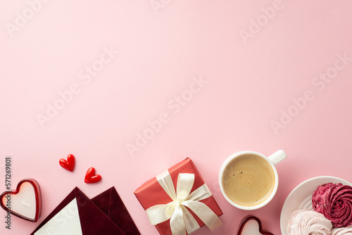 Mother's Day concept. Top view photo of red giftbox with bow envelopes plate with meringue cup of hot drinking and heart shaped candles on isolated pastel pink background with copyspace
