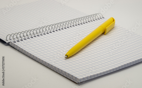 close-up notebook and yellow pen on white © Oleg