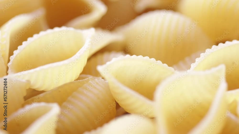 natural dry pasta in the shape of a shell close-up rotate in a circle