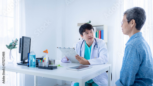 Male doctor explaining diagnosis to elderly patient in exam room. Medical checkup  healthcare and insurance concept.