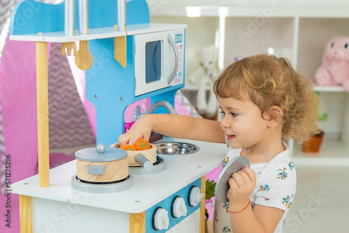 the child plays in the kitchen and cooks. Selective focus.