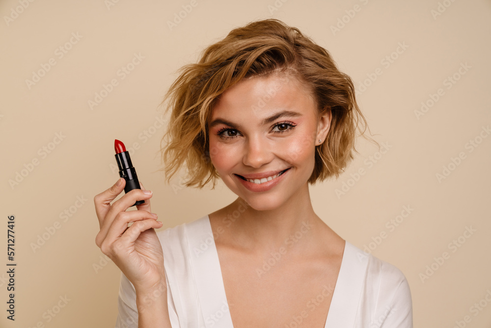 Portrait of woman posing with red lipstick isolated over beige background