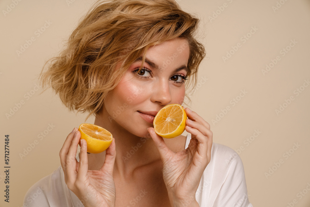Woman posing with lemon and looking at camera isolated Woman posing with lemon and looking at camera isolated