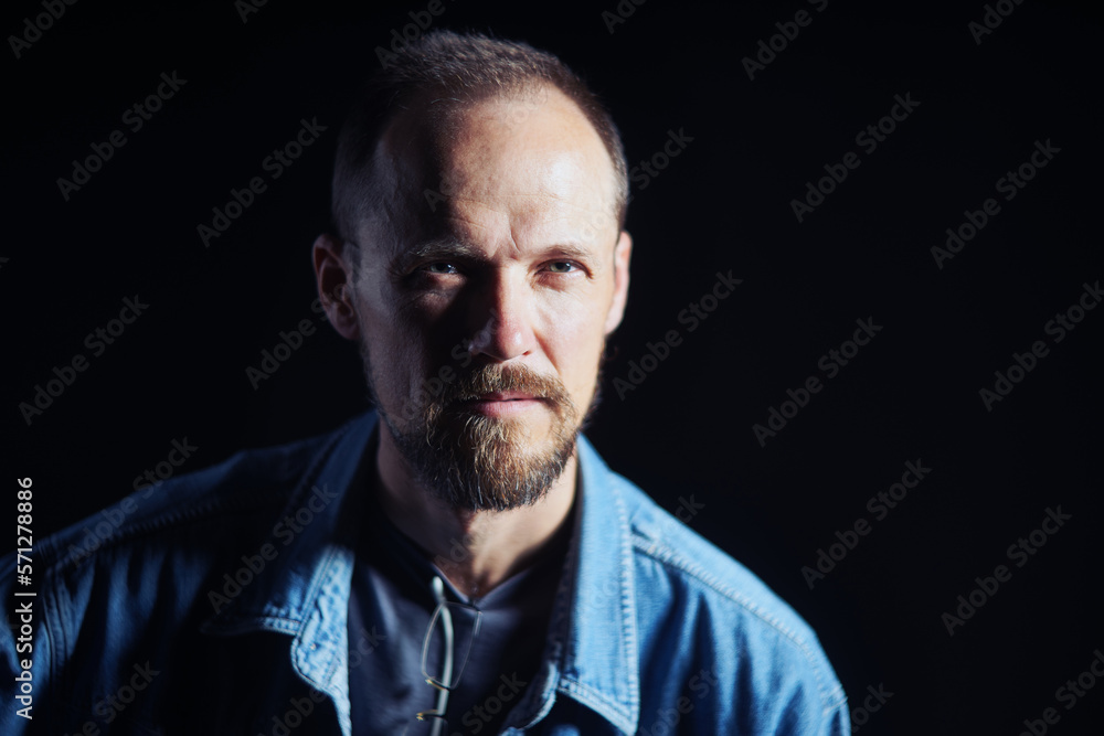Obraz premium Concentraited middle age man in denim shirt looking squinting at camera