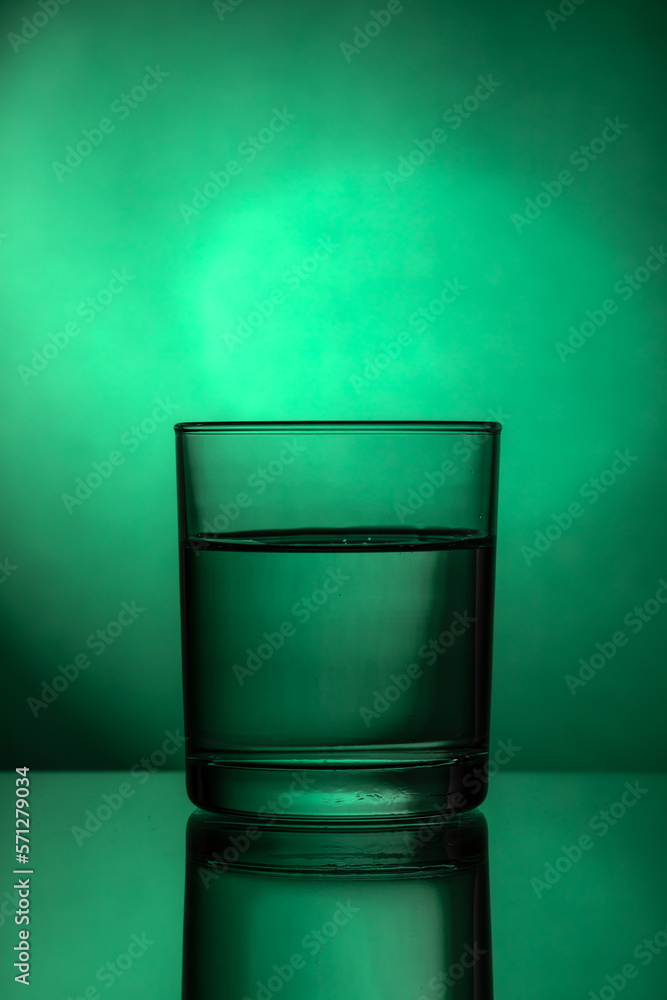 A glass of water. Glass in a backlight. Glass on the green backdrop. A glass of water. Glass in a backlight. Glass on the green backdrop.