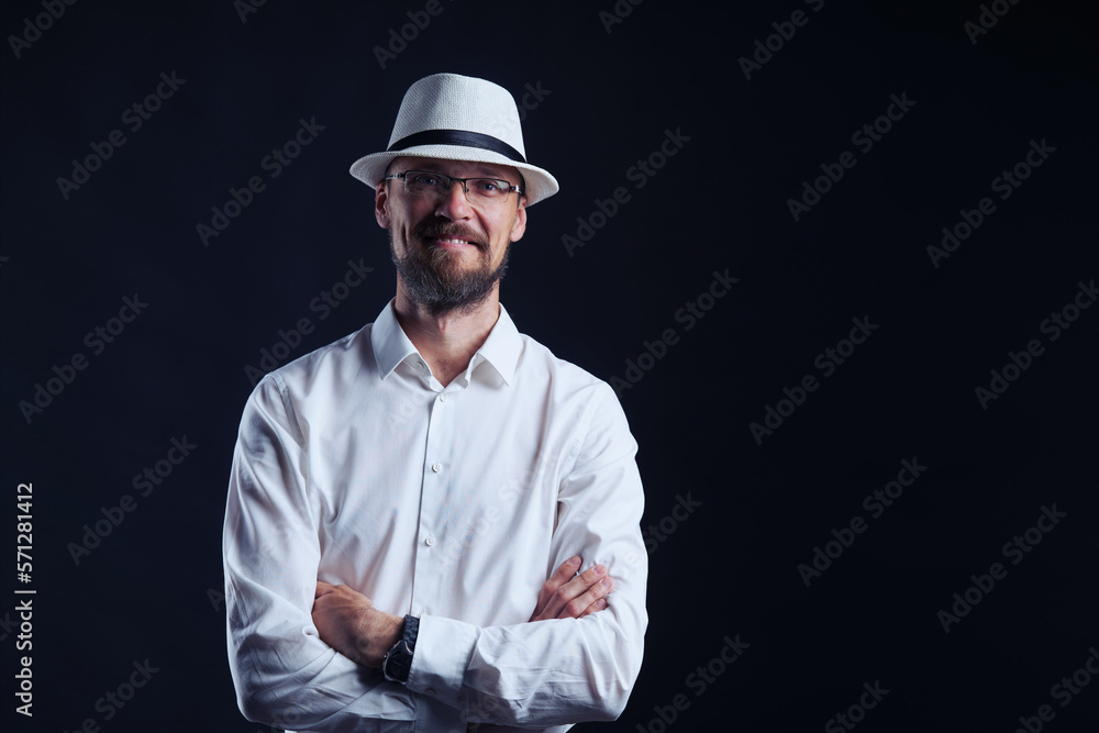 Smiling middle age man in white shirt and hat standing with folded hands looking at camera Smiling middle age man in white shirt and hat standing with folded hands looking at camera