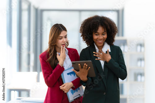 Young trader mixed race woman in formal suit friends consulting and discussing with stock market and cryptocurrency in online trading application. Shock, surprise